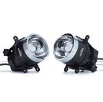 Two black and silver automotive headlights on a white background

