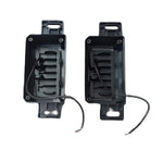 Two black rectangular electronic components with wires on a white background

